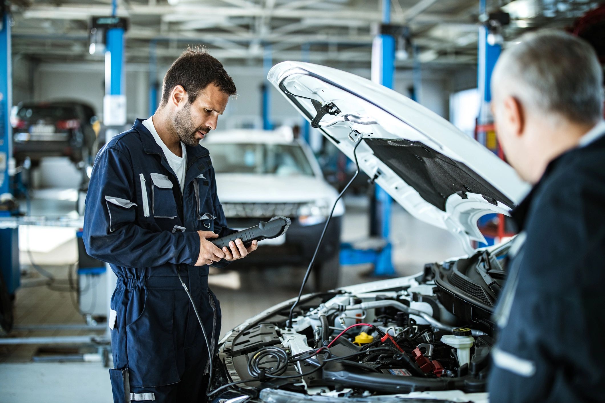 Mechanic reviewing a maintenance checklist with a diagnostic tool