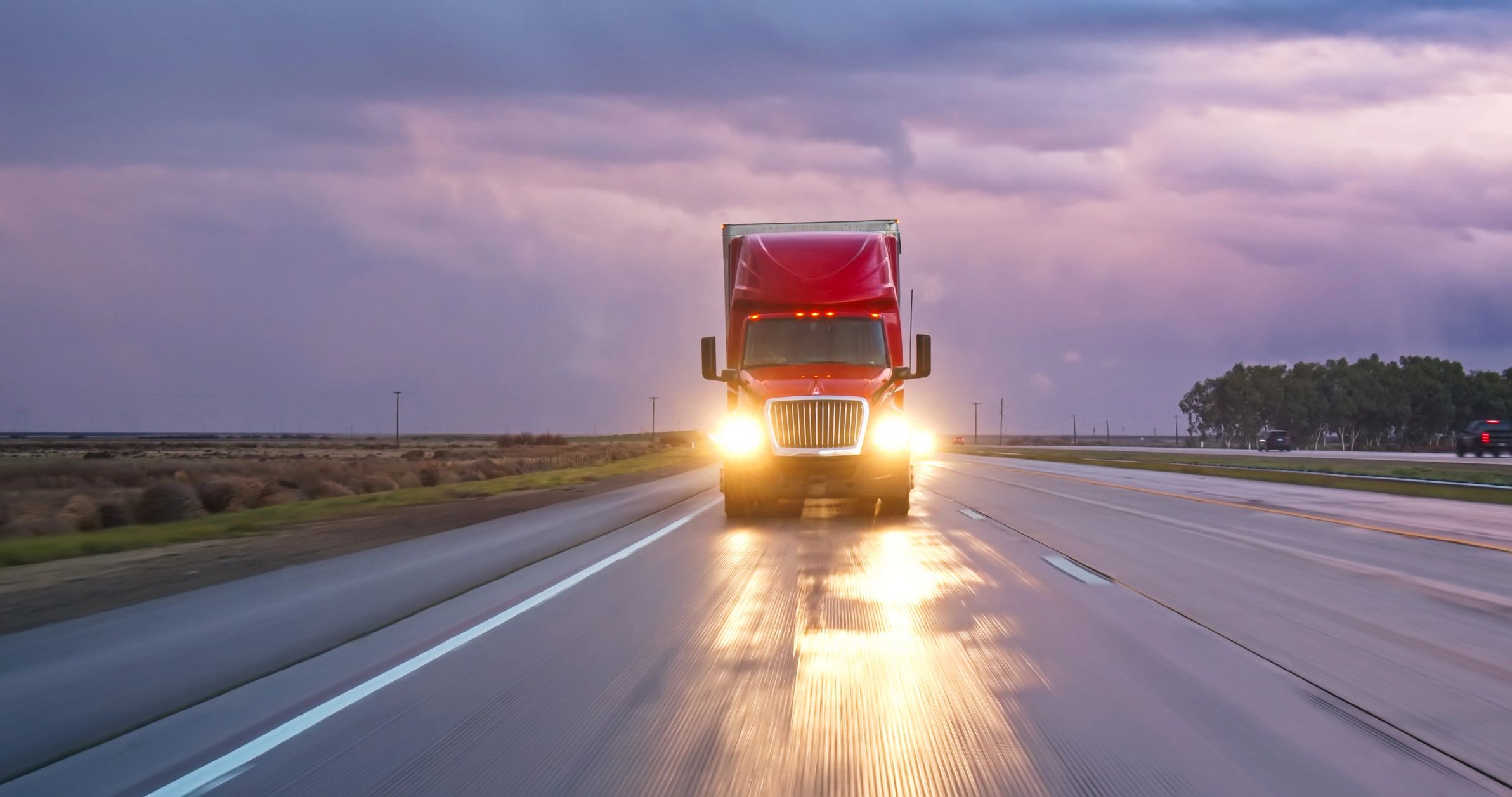 Heavy-duty truck on the road at dusk